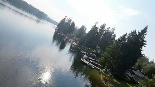 Fixed wing FPV drone flying low over a lake in the Pacific Northwest